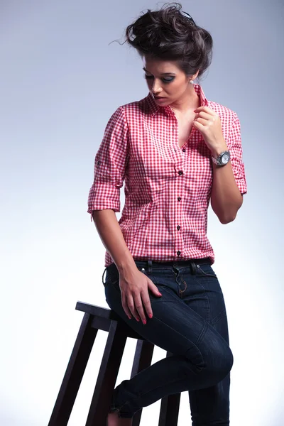 Драматическая картина серьезной женщины-модницы, сидящей — стоковое фото