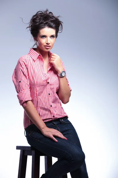 Casual woman sitting on a chair and looking away — Stock Photo, Image