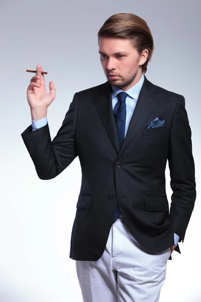 Snygga business man ser ned med cigarett i handen — Stockfoto