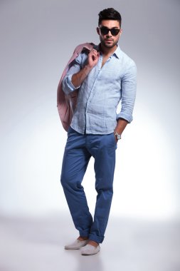 Casual adam kameraya ceket omzunda görünüyor