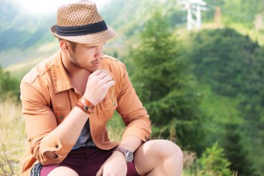 seated casual man holds a straw in his mouth, outdoor clipart