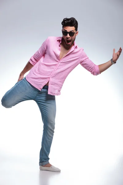 Young fashion man balancing with one leg in his hand — Stock Photo, Image