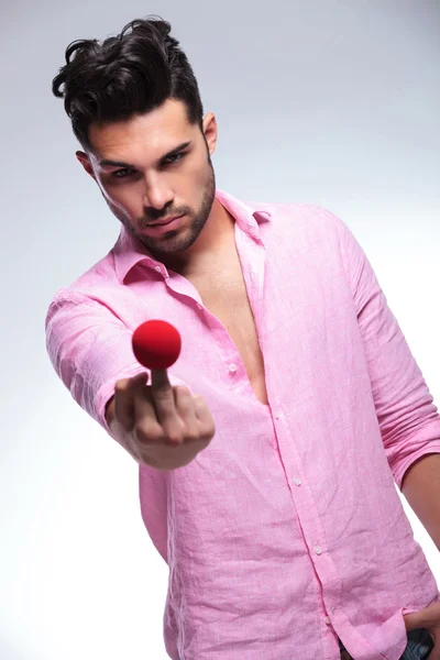 Fashion young man with a red nose on his middle finger — Stock Photo, Image