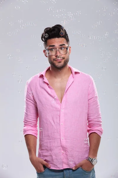 Young fashion man with hands in pockets among bubbles — Stock Photo, Image