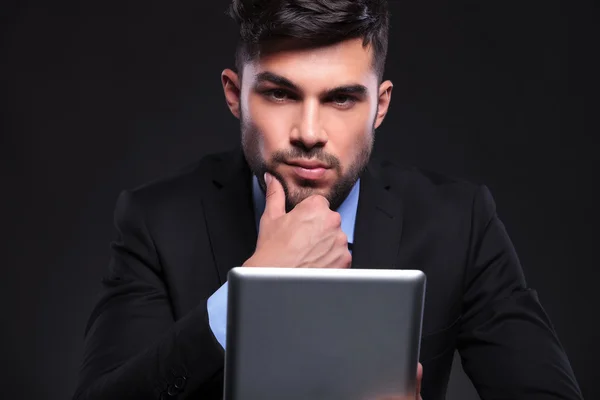 Jovem homem de negócios com tablet olha para você de forma penosa — Fotografia de Stock