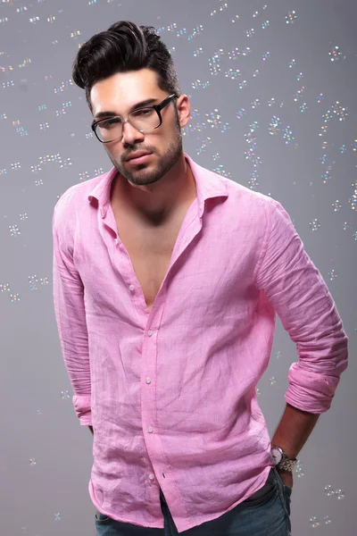 Young fashion man with hands in back pockets among bubbles — Stock Photo, Image