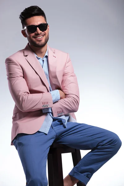 Seated casual man with hands folded smiles — Stock Photo, Image