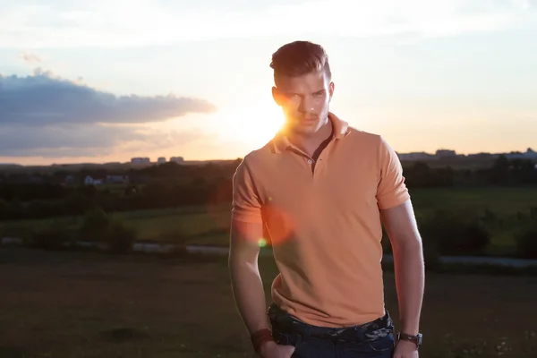 Hombre casual con puesta de sol detrás te mira —  Fotos de Stock