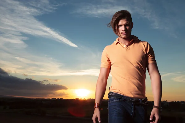 Casual man looks at you with sunset behind — Stock Photo, Image