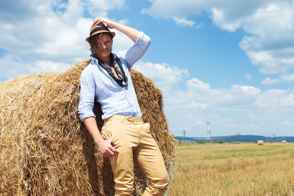 Casual homme extérieur vous regarde avec la main sur le chapeau — Photo