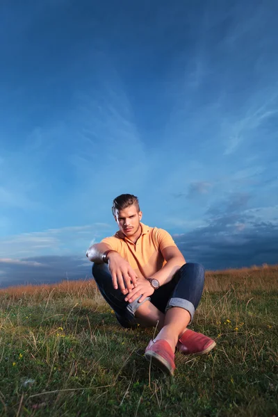 Casual man sits outside and looks at you — Stock Photo, Image