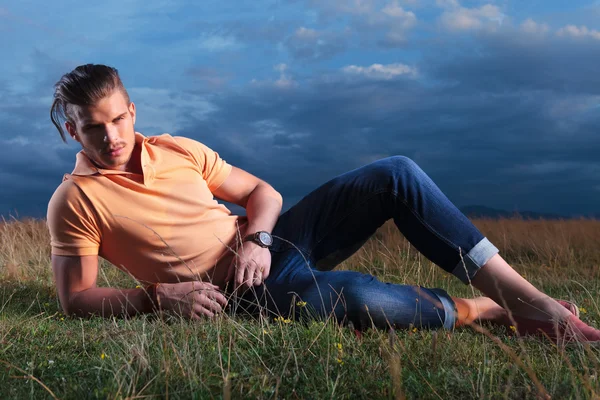 Casual man in the grass looking at you — Stock Photo, Image