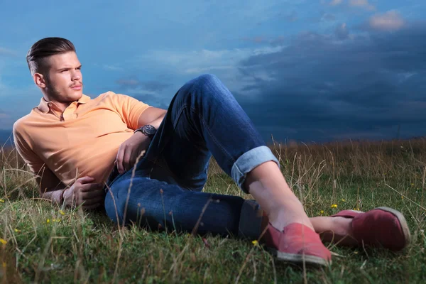 Casual man laying with feet crossed in the grass — Stock Photo, Image