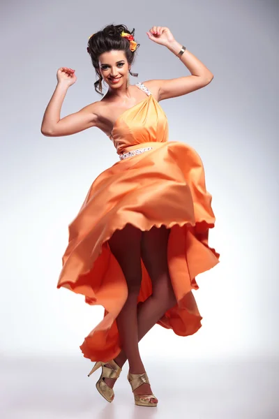 Beauty woman dancing with her dress in the air — Stock Photo, Image