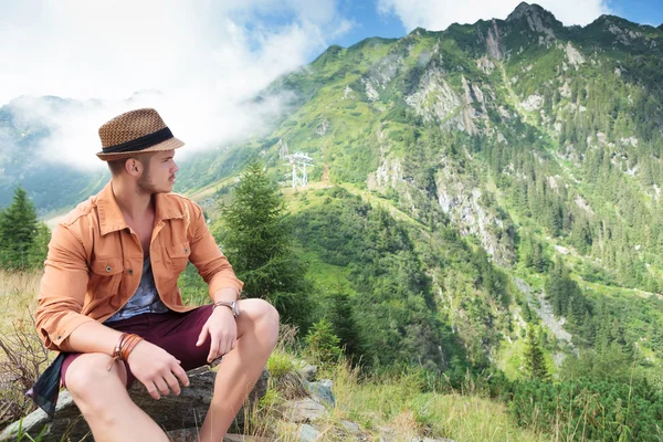 Casual man looks back at mountain — Stock Photo, Image