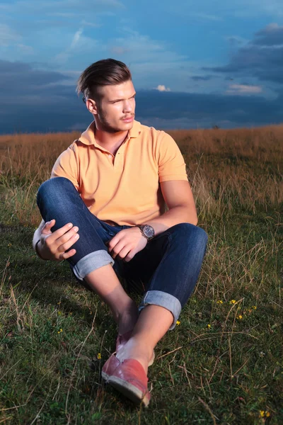 Casual man in the grass looking away — Stock Photo, Image