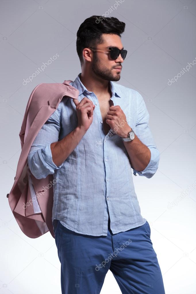 casual man looks away with jacket over shoulder