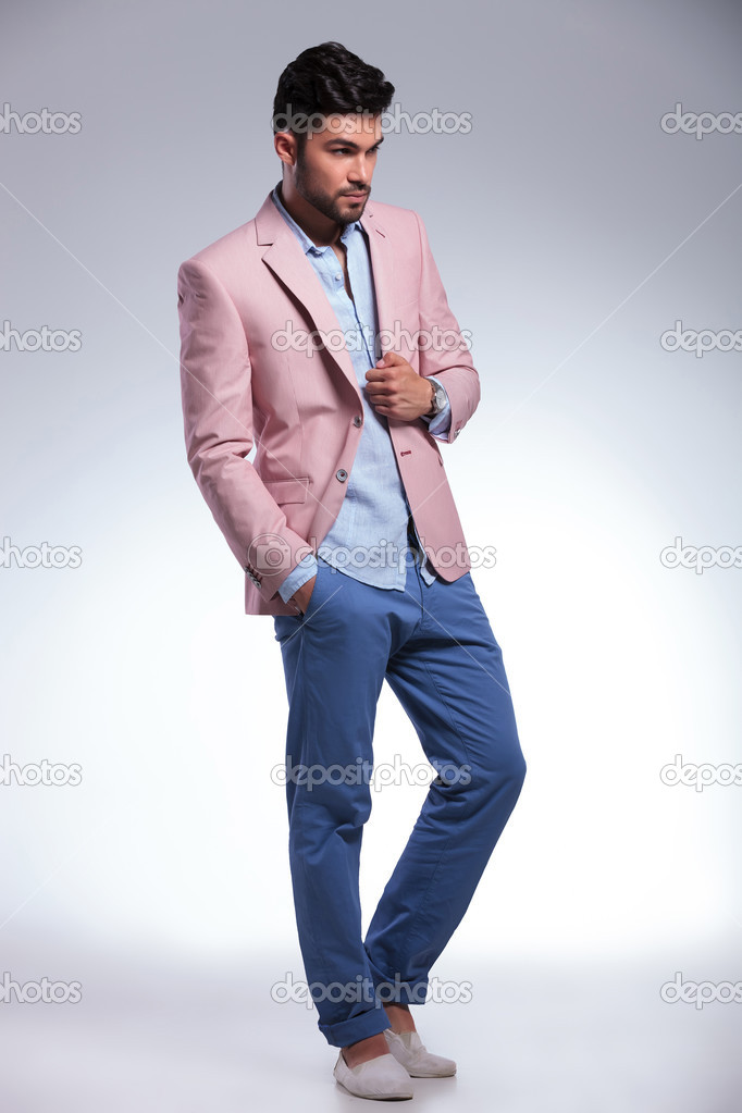 casual man with hand on jacket looks away