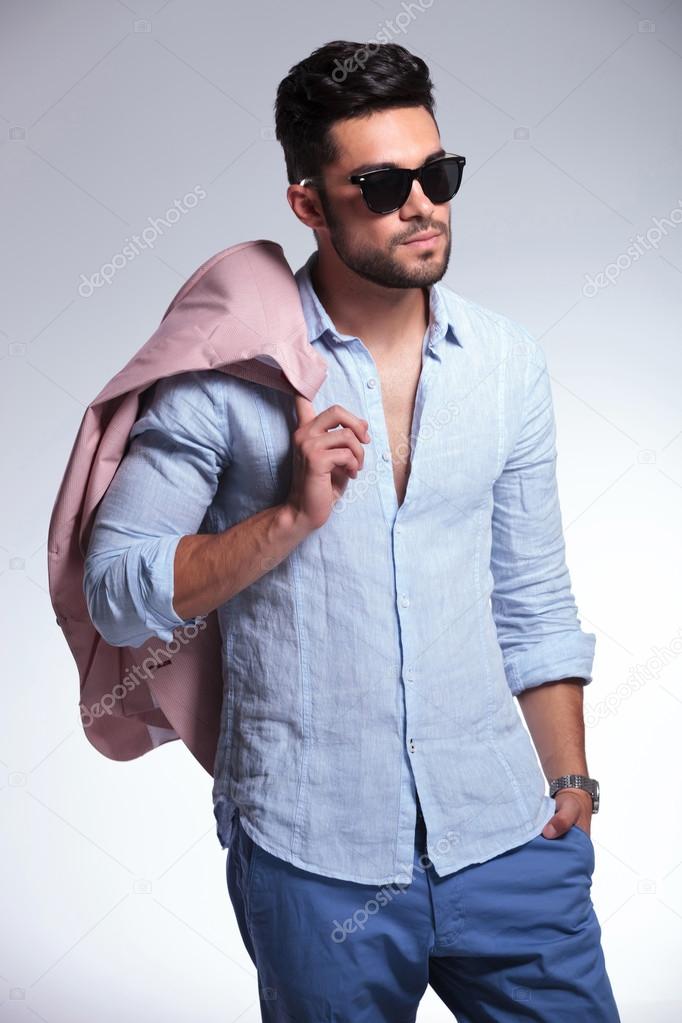casual man looks away and holds jacket on shoulder