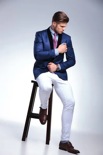 Seated young business man fixes his chest napkin — Stock Photo, Image