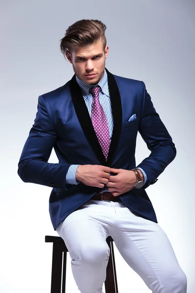 Seated young business man taking his jacket off — Stock Photo, Image