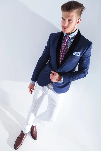 Jonge zakenman kijkt naar je met de hand op jas — Stockfoto