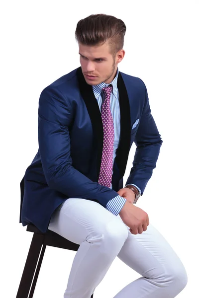 Seated young business man looks to his side — Stock Photo, Image