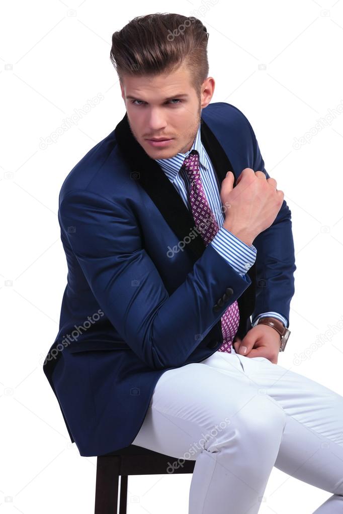 seated young business man with elbow on leg