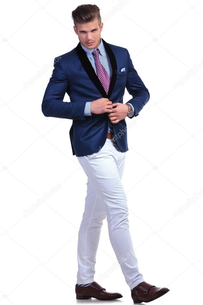 young business man unbuttoning jacket while walking