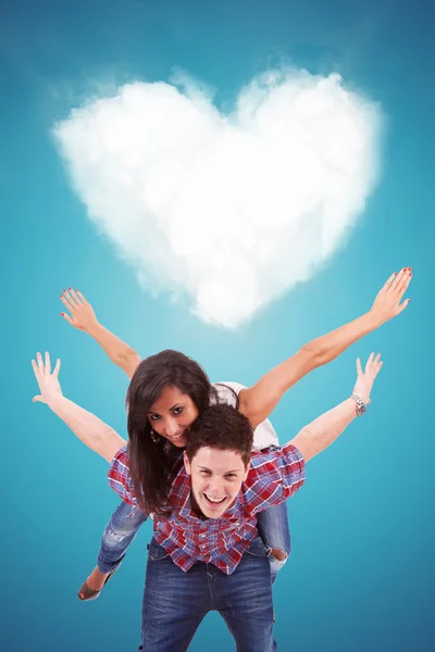 Handsome casual young man carrying his girlfriend on his back — Stock Photo, Image