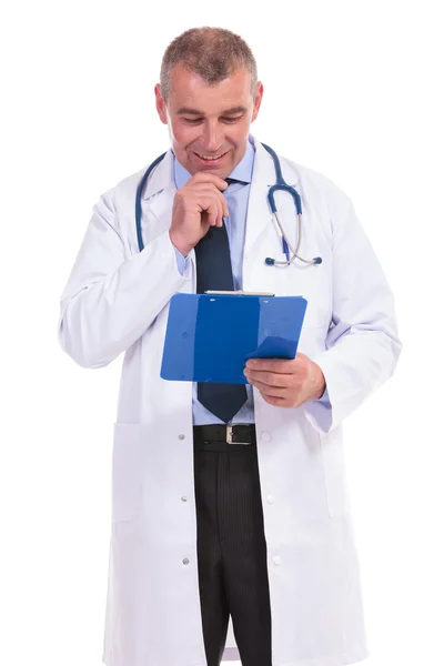 Mature doctor reading the results and smiles Royalty Free Stock Images