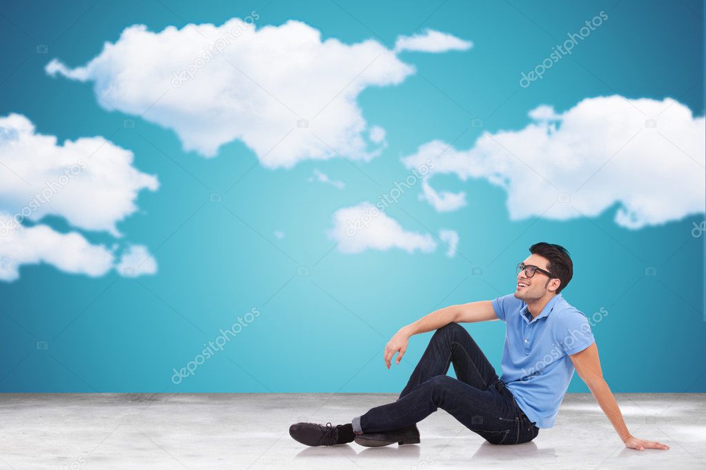 young man on the floor looking away to clouds