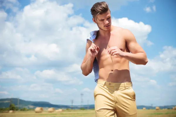 Topless man buiten kijkt naar beneden met stro in de hand — Stockfoto