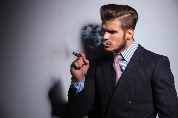 Modelo de moda en traje y corbata disfrutando de su cigarro — Foto de Stock