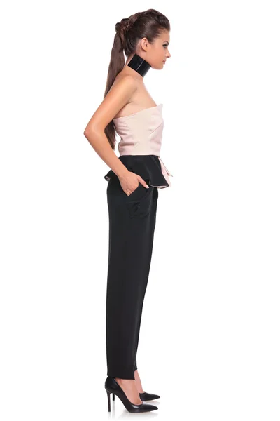 Side view of a young woman with hands in her pockets — Stock Photo, Image