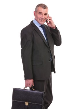 iş adamı evrak çantası ile telefonda konuşuyor.