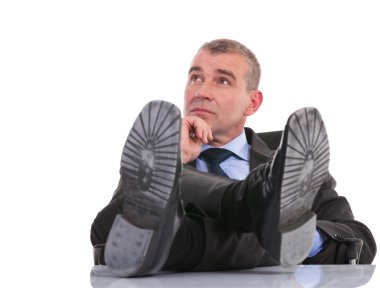 iş adamı ve ayakları masaya oturur düşünüyor