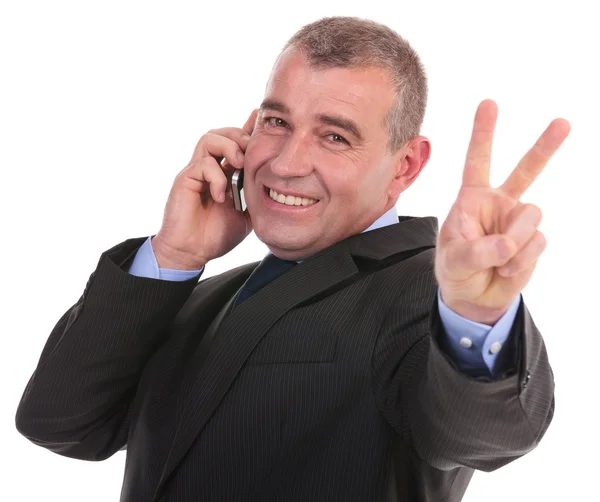 Business man on phone shows victory — Stock Photo, Image