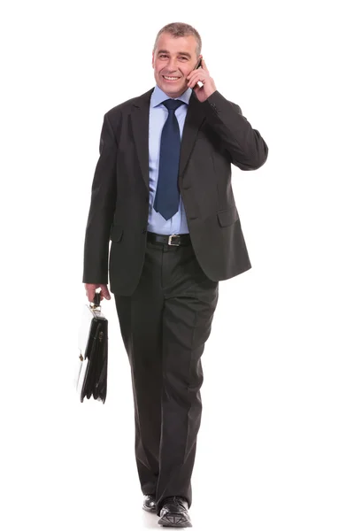 Business man walks with briefcase and on phone — Stock Photo, Image