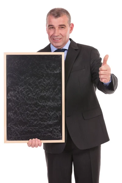 Business man with blackboard shows thumb up — Stock Photo, Image