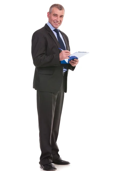 Business man writes on his clipboard — Stock Photo, Image