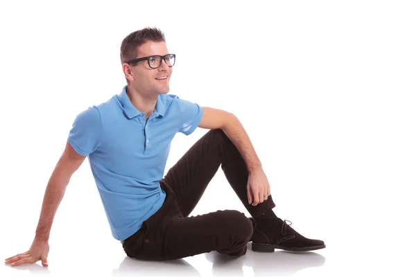 Casual man smiles while sitting on the floor — Stock Photo, Image