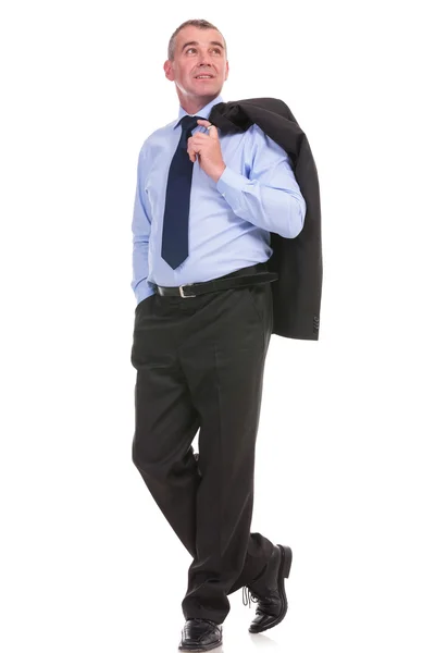 Hombre de negocios mira hacia otro lado y sostiene la chaqueta sobre el hombro —  Fotos de Stock