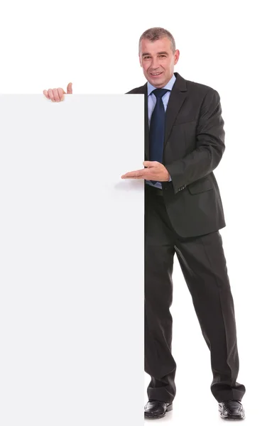 Homem de negócios apresenta um quadro em branco — Fotografia de Stock