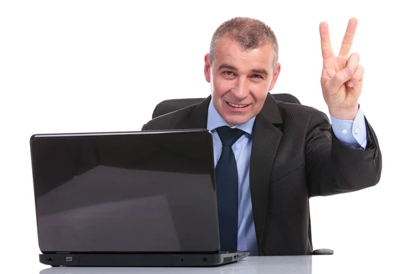 Business man at laptop, shows victory sign — Stock Photo, Image