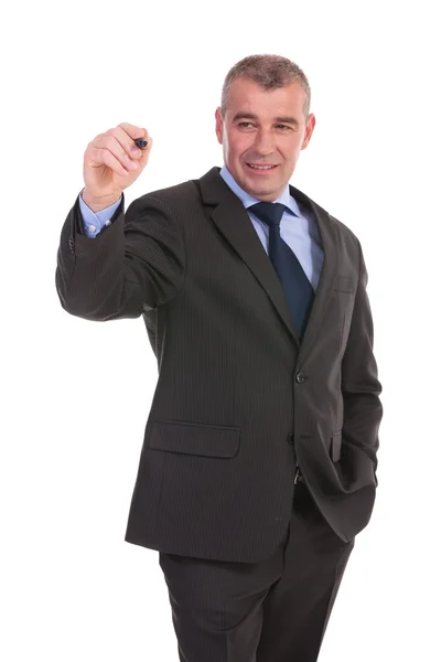 Business man writes while holding a hand in pocket — Stock Photo, Image