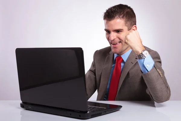 Jonge zakenman prosit tijdens het lezen van op laptop — Stockfoto