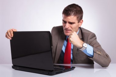 genç iş adamı laptop yumruk atmak istiyor.