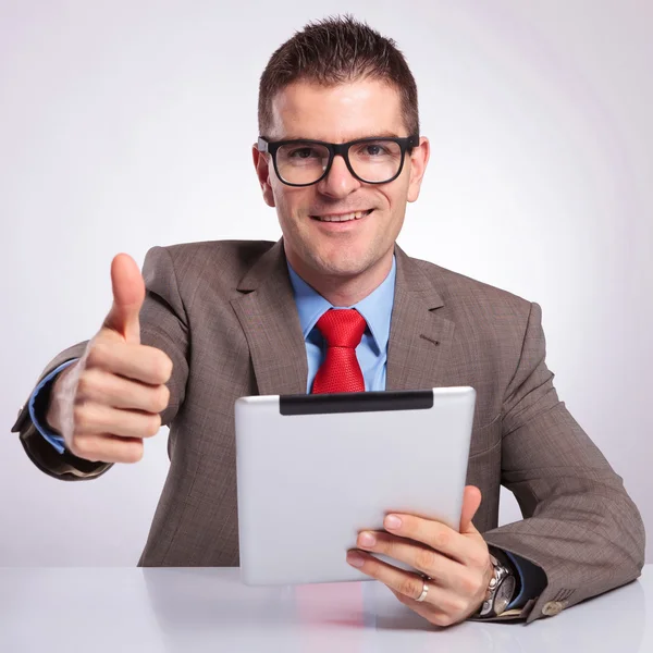 Young business man with tablet shows thumb up gesture — Stock Photo, Image