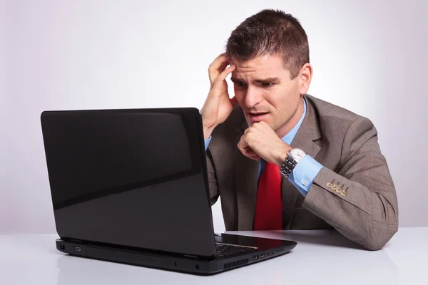 Young business man looks disappointed at laptop — Stock Photo, Image